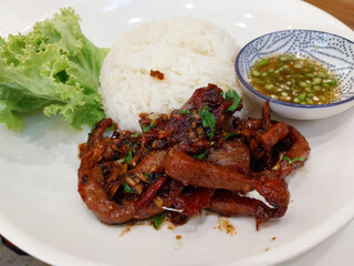 Thai style Deep Fried Pork with rice, salad vegetable and fish sauce chili. Deep Fried Sun-Dried Pork. Popular street food in Thailand.