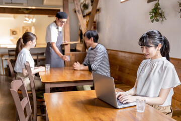 カフェ・喫茶店・飲食店でリモートワークするアジア人女性
