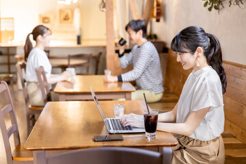 カフェ・喫茶店でPCを使うリモートワークするライター・ブロガーの女性
