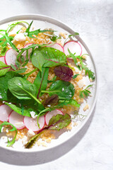 Light, dietary salad with bulgur, fresh spinach, radish, arugula and various types of greens. Dietary healthy balanced nutrition, vegan recipes. Nord Africa, French recipes, close up
