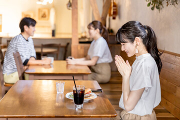 レストラン・カフェでランチ・昼食を食べるアジア人女性（いただきます）
