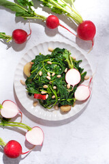 Spring and summer Italian-style cooked radish tops with chili peppers, olive oil, pine nuts and garlic. Eco no waste recipes, radish leaves full of vitamins and minerals, veggie recipe