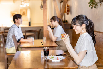 レストラン・カフェでランチ・昼食を食べるアジア人女性
