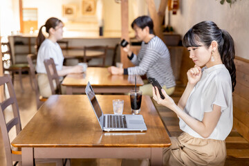 Fototapeta premium カフェ・喫茶店でスマホ・PCを使う困る・考えるフリーランスのビジネスウーマン 
