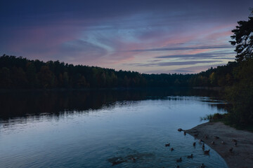 Stunningly beautiful lake in the golden autumn season. Magical multi-color reflection with light ripples on the surface of the water fall evening. Autumn scenery Colorful vibrant autumn forest with