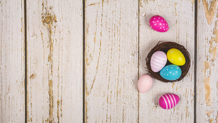 Colorful Easter eggs on white wooden background. Easter holiday concept, flat lay, top view. Copy space. Banner