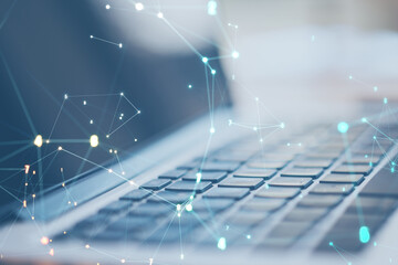 Close up of laptop with glowing polygonal coding mesh on blue background. Technology and pattern concept. Double exposure.