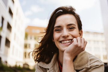 Young woman in the city laughing and leaning on her hand