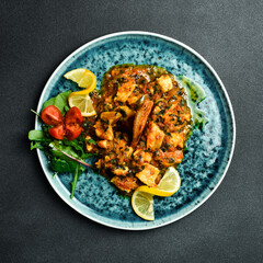 Pieces of sturgeon stewed with vegetables. Fish menu. Free space for text. Close up.