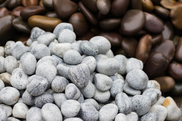 White and brown stones or pebbles of round shapes kept in piles.