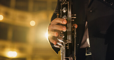 Cinematic Closeup of the Hands of a Male Saxophone Player Playing his Instrument. Professional Musician Rehearsing Before the Start of a Big Jazz Show on a Classical Theatre Stage