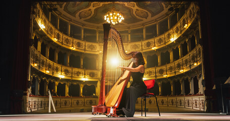Cinematic shot of Female Harpist with Medical Mask Playing Harp Solo on an Empty Classic Theatre...