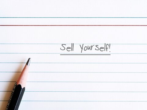 Pencil on lined notebook with text written SELL YOURSELF, concept self marketing in professional business world to get hiring or make money with or writing from customers