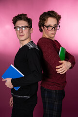Two young attractive students are posing in the studio.	 Happy men. 