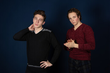 Two young attractive students are posing in the studio.	 Happy men. 