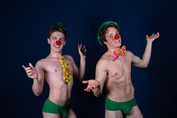 Two young attractive guys in clown costumes. 
