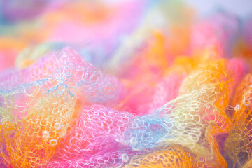 Knitted surface woolen items rainbow colored as a background. Closeup of soft multicolored knitted texture patterns. Warm winter clothes. Background textile surface with copy space for text. blurred