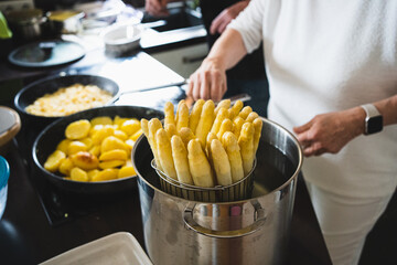 Old Woman cooking white asparagus in the kitchen