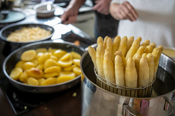 Old Woman cooking white asparagus in the kitchen