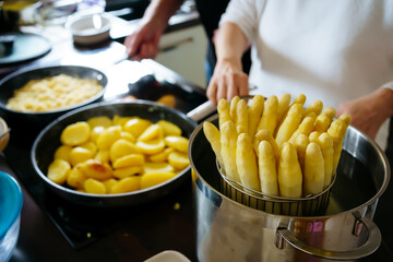 Old Woman cooking white asparagus in the kitchen