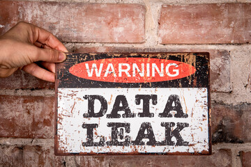 Data Leak. Warning sign with text, red brick background