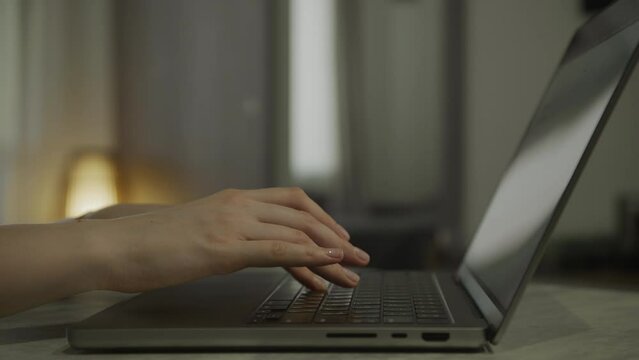 Hands typing on laptop computer, IT employee working close up
