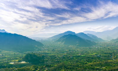 landscape of green summer highland mountain range with green beautiful valley below and amazing blue cloudy sky