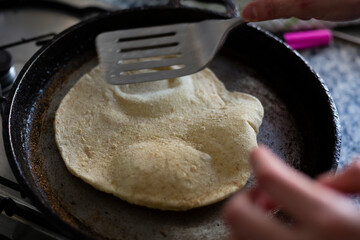 Cooking pita bread on a pan.