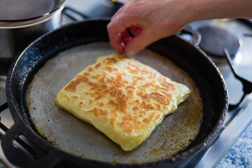 Cooking traditional moroccan rghayf or msemmen on a pan. Moroccan breakfast concept.