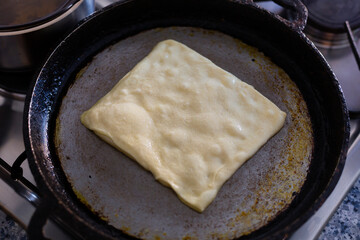 Raw dough on a pan. Cooking raditional rghayf or msemmen originally from north Africa.