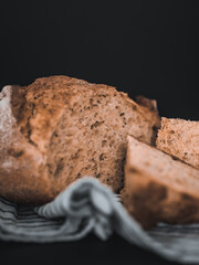 Bread, traditional sourdough bread cut into slices on a dark background. Healthy food.