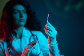 Dark-haired doctor witha syringe in hand