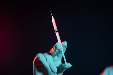 Doctor holding a syringe in hand and getting ready for injection