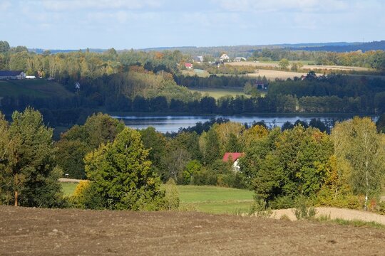 Beautiful scenery of kashubian landscape with fields and trees on hills in autumn scenery. Little houses  among fields. Around Sierakowice, Kashubia, Poland