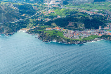 aerial of village Castro Urdiales with 2 piers and sandy beach in Cantabria,