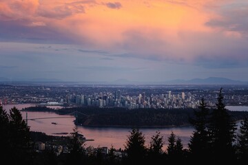 Fototapeta premium Aerial view of colorful sunset cloudscape over the river and Vancouver cityscape at a distance