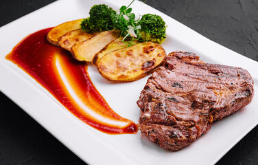 Steak with baked potatoes on plate
