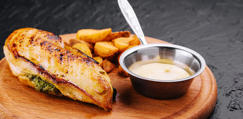 Fried chicken served with sauce and garnish on wooden board
