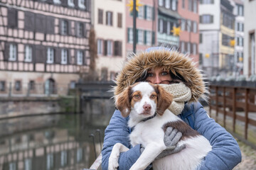 Young blue eyed woman carrying her dog