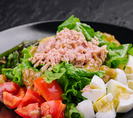 Tuna and vegetable salad on black plate