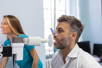 Man performing pulmonary function test and spirometry using spirometer at medical clinic....