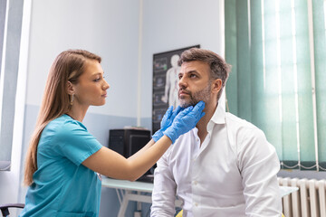 Endocrinologist examining throat of man in clinic. Men with thyroid gland test . Endocrinology,...