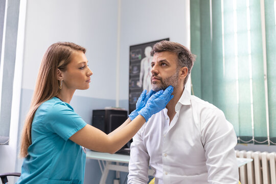 Endocrinologist examining throat of man in clinic. Men with thyroid gland test . Endocrinology, hormones and treatment. Inflammation of the sore throat