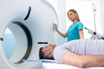 Female Doctor Looking At Patient Undergoing CT Scan. Doctor in uniform using tomography machine with lying patient in hospital