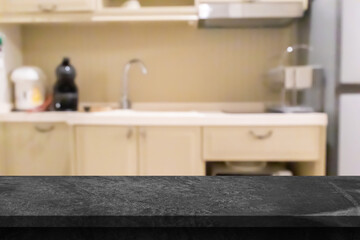 Black marble stone counter top with blurred kitchen background