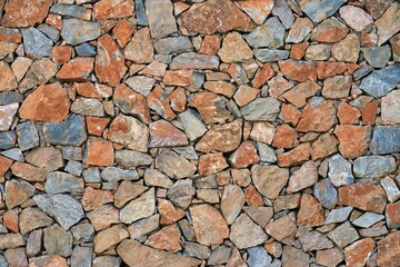 Closeup shot of a stone facade, with differently colored stacked stones