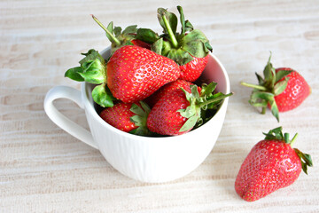 A cup of red strawberries on a table isolated, close-up