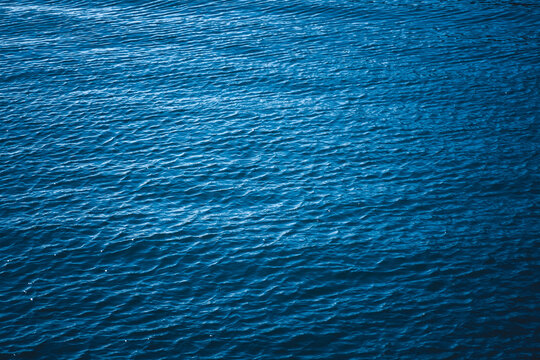 Abstract natural background. Azure sea water with ripples on the surface. Сopy space, shot from top