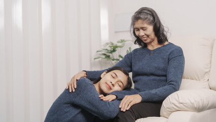 Mother's day concept, young adult female daughter congratulate excited asian elderly mother at sofa with birthday anniversary, two generations family photo, real people.