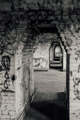 Vertical grayscale of an abandoned building with graffiti notes on the inner walls